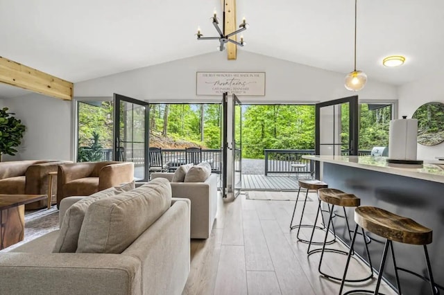 living room with vaulted ceiling with beams, a notable chandelier, plenty of natural light, and light hardwood / wood-style floors