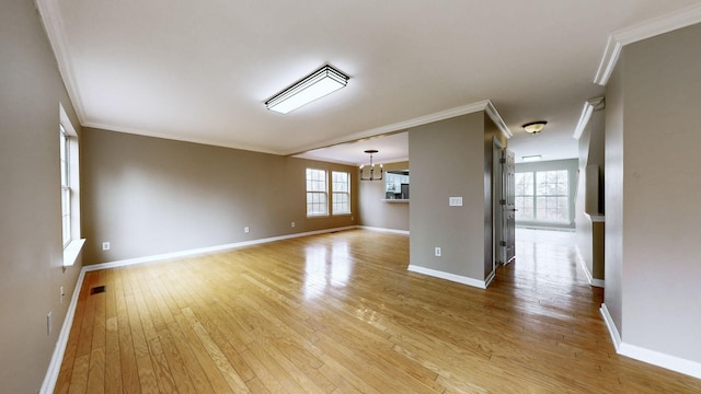 spare room with crown molding, light hardwood / wood-style flooring, and a chandelier