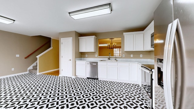 kitchen featuring sink, stainless steel appliances, hanging light fixtures, and white cabinets