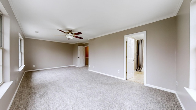 empty room with crown molding, light colored carpet, and ceiling fan