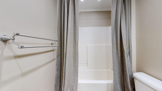 bathroom featuring shower / tub combo and toilet