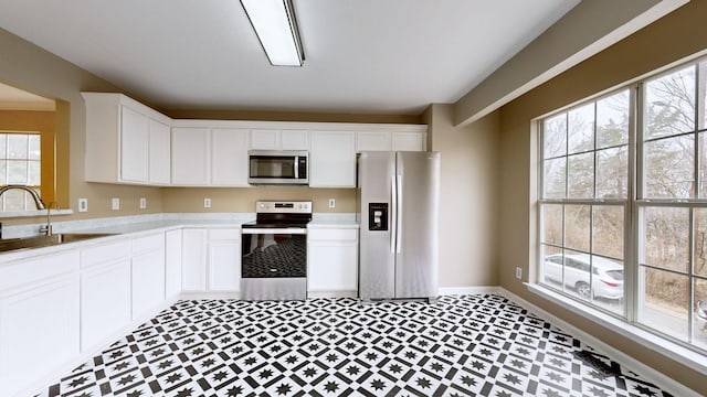 kitchen with sink, stainless steel appliances, and white cabinets