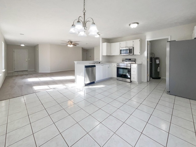 kitchen with decorative light fixtures, light tile patterned floors, appliances with stainless steel finishes, water heater, and white cabinets