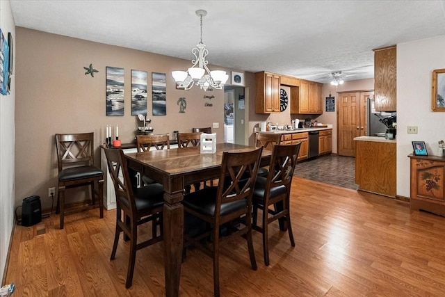 dining area featuring ceiling fan with notable chandelier and hardwood / wood-style floors