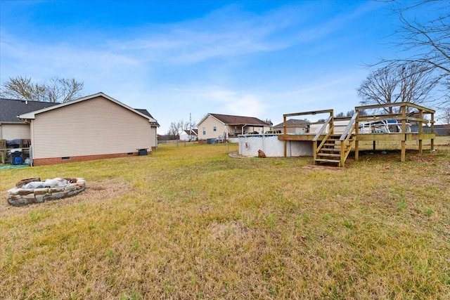 view of yard with a swimming pool side deck and an outdoor fire pit