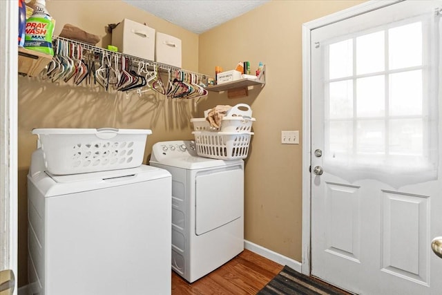 washroom with washing machine and dryer, hardwood / wood-style floors, and a textured ceiling