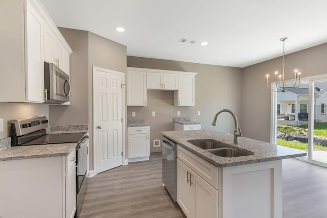 kitchen featuring sink, white cabinetry, a center island with sink, appliances with stainless steel finishes, and pendant lighting