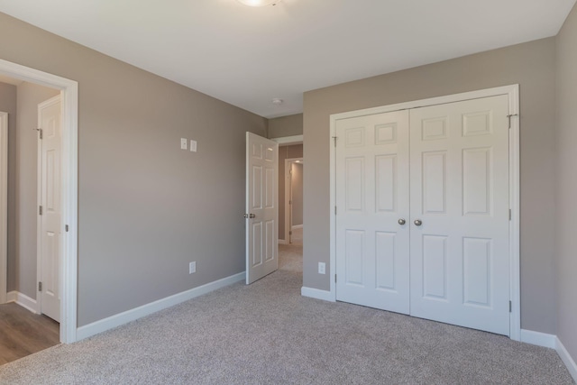 unfurnished bedroom with light colored carpet and a closet