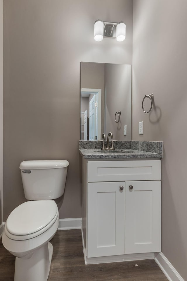 bathroom featuring vanity, hardwood / wood-style flooring, and toilet