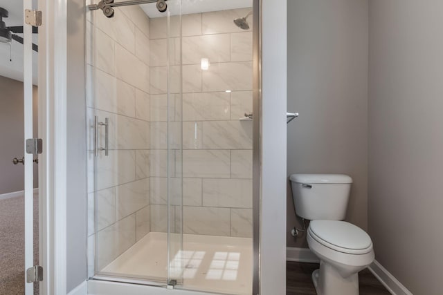 bathroom featuring toilet and a shower with door