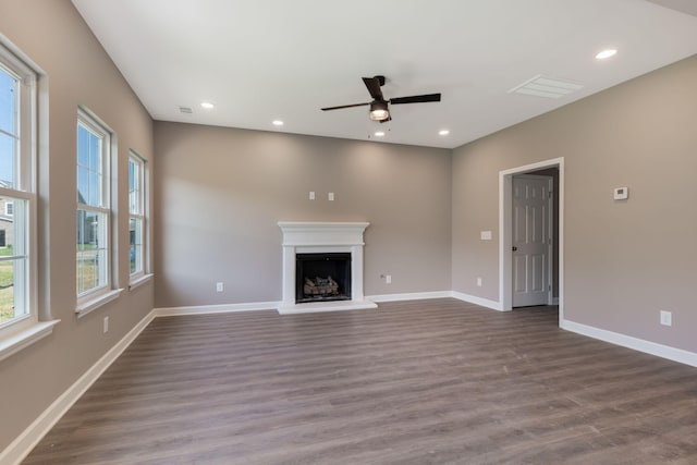 unfurnished living room featuring ceiling fan and dark hardwood / wood-style flooring