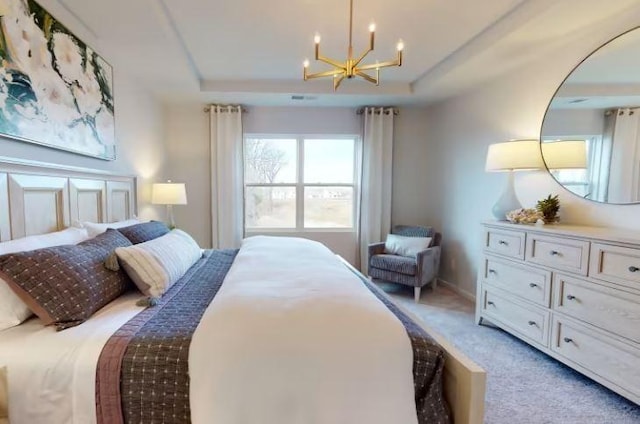 carpeted bedroom featuring a raised ceiling and a notable chandelier