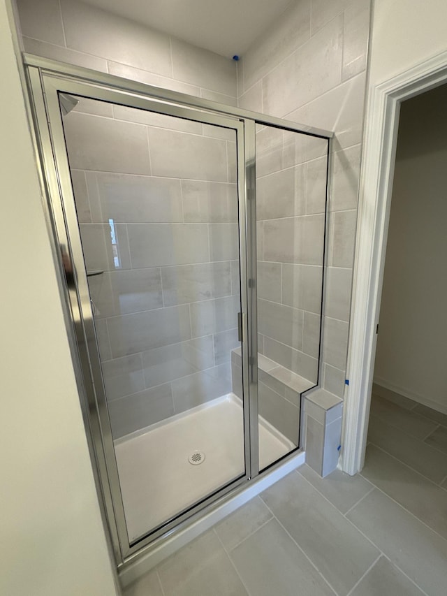 bathroom featuring an enclosed shower and tile patterned flooring