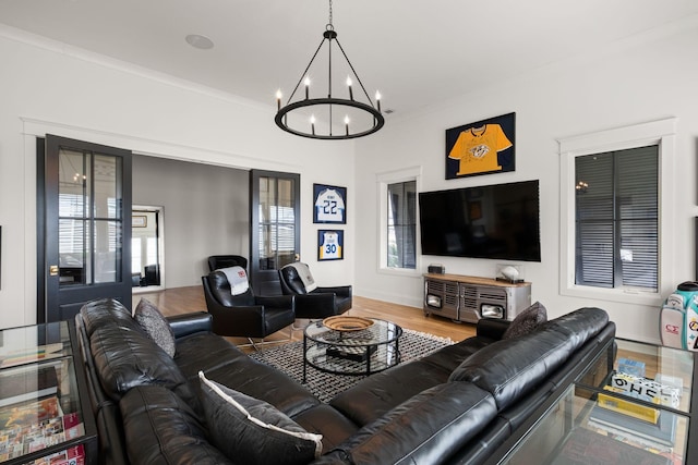 living room featuring hardwood / wood-style flooring, crown molding, and a chandelier