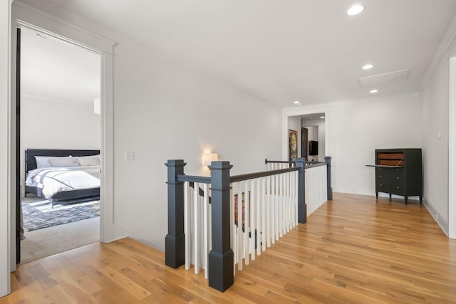 hallway with ornamental molding and light hardwood / wood-style floors