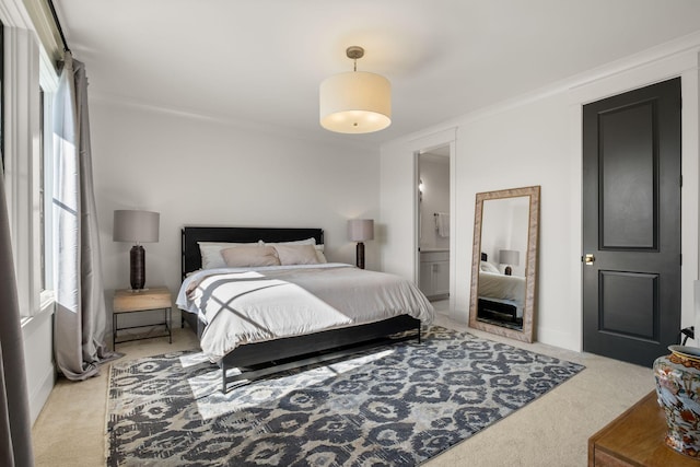 bedroom with light colored carpet and ensuite bath