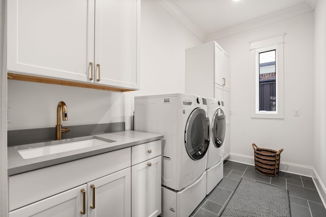 laundry room featuring sink, cabinets, ornamental molding, dark tile patterned floors, and independent washer and dryer