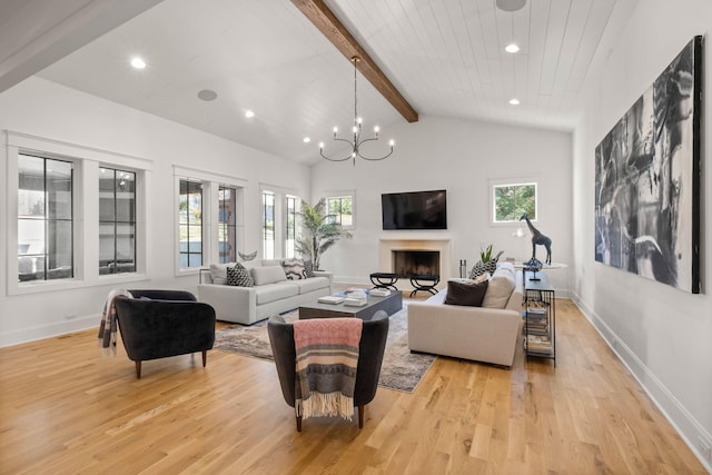 living room with plenty of natural light, a chandelier, light hardwood / wood-style floors, and vaulted ceiling with beams