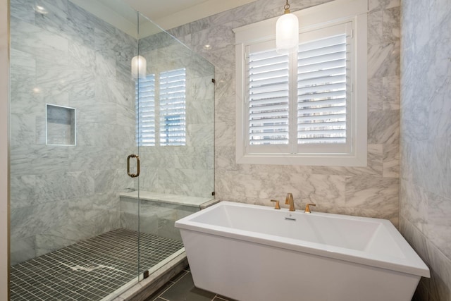 bathroom featuring plus walk in shower and tile walls