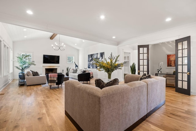 living room featuring an inviting chandelier, light hardwood / wood-style flooring, lofted ceiling with beams, and french doors