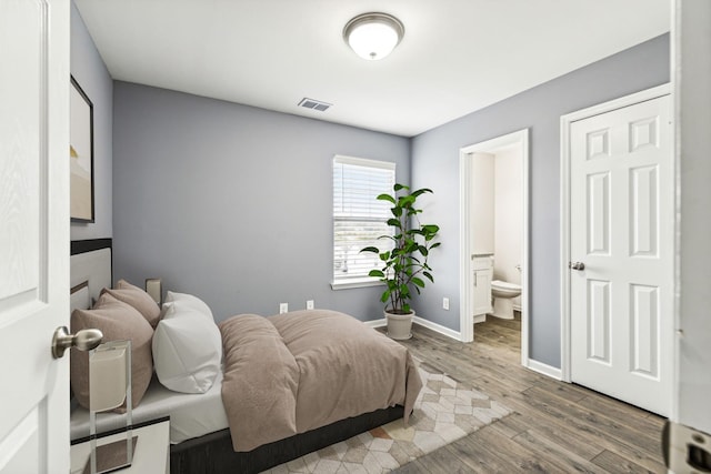 bedroom featuring wood-type flooring and ensuite bathroom