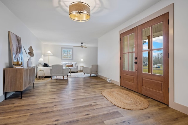 foyer entrance with light hardwood / wood-style floors and french doors