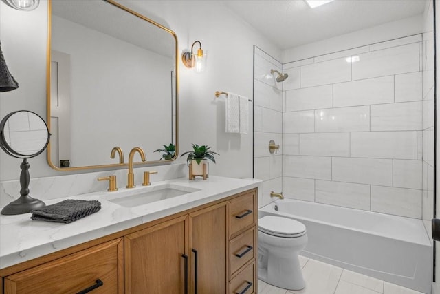 full bathroom featuring vanity, tile patterned floors, toilet, and tiled shower / bath