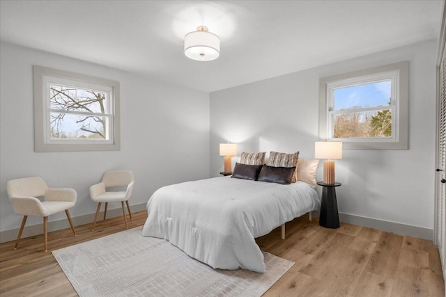 bedroom featuring multiple windows and light hardwood / wood-style floors