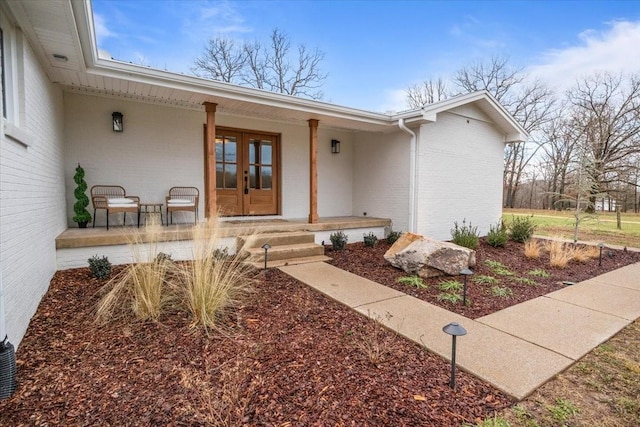 view of exterior entry with french doors and a porch