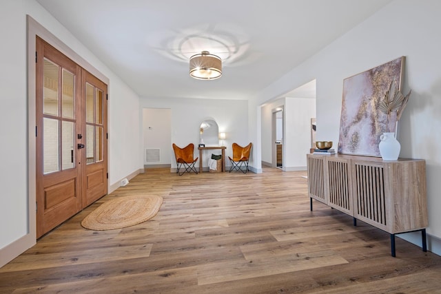 hallway featuring french doors and light wood-type flooring