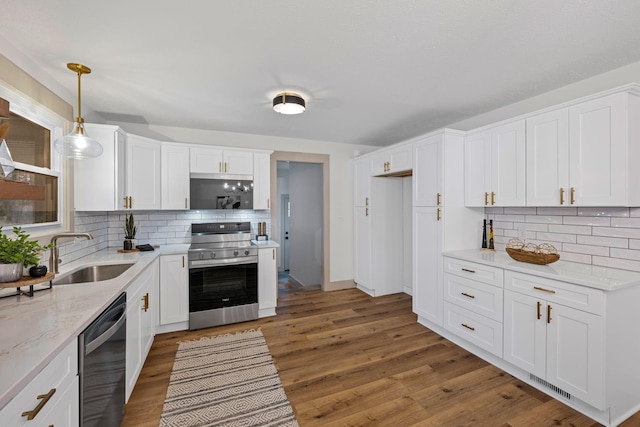 kitchen with pendant lighting, sink, white cabinetry, and appliances with stainless steel finishes