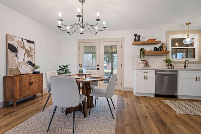 dining area featuring french doors, sink, and light wood-type flooring