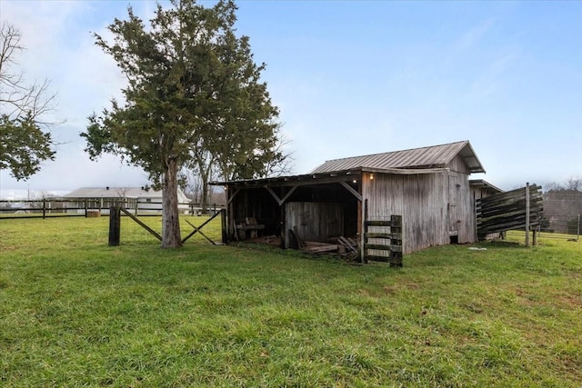 view of outdoor structure with a rural view and a lawn