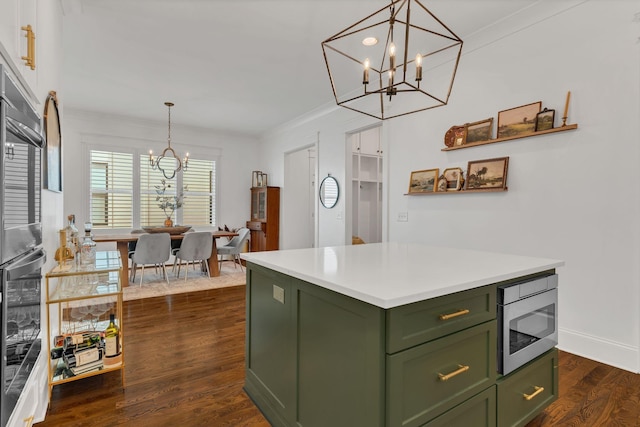 kitchen with a kitchen island, stainless steel microwave, decorative light fixtures, green cabinets, and an inviting chandelier