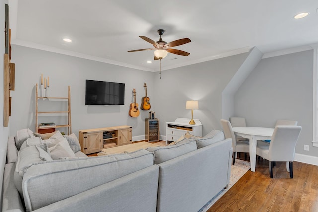 living room with crown molding, light hardwood / wood-style floors, and ceiling fan