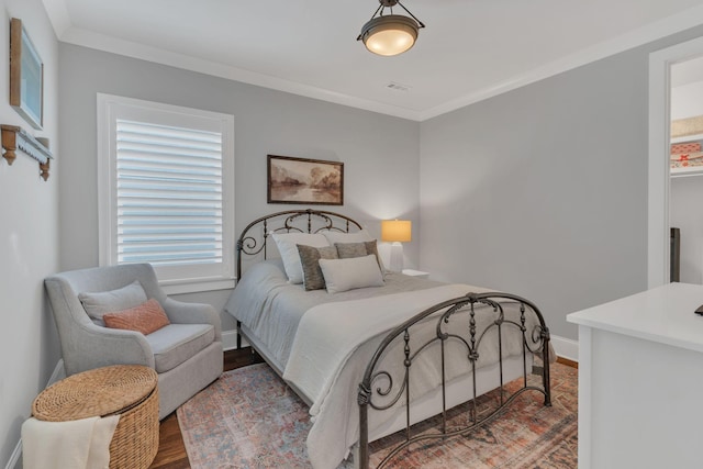 bedroom with hardwood / wood-style flooring and ornamental molding