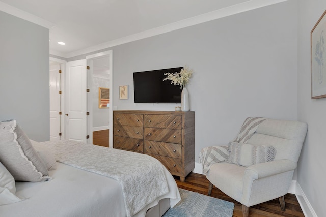 bedroom with ornamental molding and dark hardwood / wood-style floors