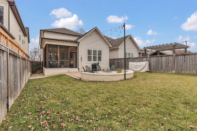 rear view of house with a pergola, a patio area, a sunroom, and a lawn