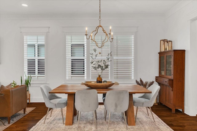 dining space with crown molding, dark hardwood / wood-style floors, and a chandelier