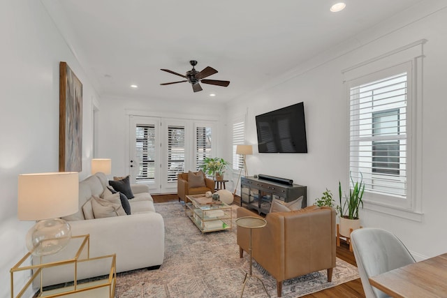 living room featuring wood-type flooring, a healthy amount of sunlight, and ceiling fan