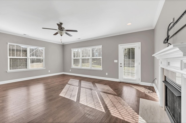 unfurnished living room with dark wood-type flooring, ceiling fan, ornamental molding, and a fireplace