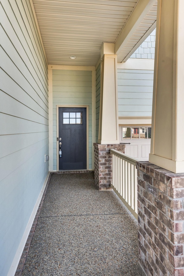 view of exterior entry featuring covered porch