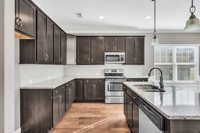 kitchen featuring appliances with stainless steel finishes, decorative light fixtures, sink, and dark brown cabinets