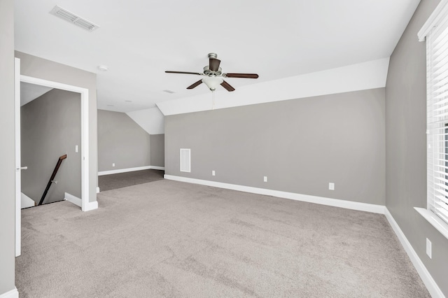 additional living space featuring lofted ceiling, plenty of natural light, light colored carpet, and ceiling fan