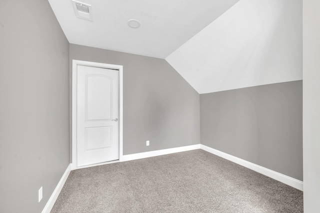 additional living space featuring vaulted ceiling and carpet