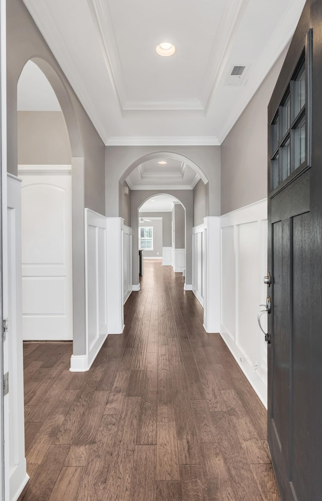 corridor featuring crown molding, dark hardwood / wood-style floors, and a tray ceiling