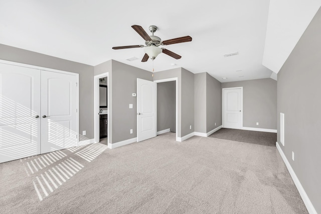 unfurnished bedroom featuring light carpet, a closet, and ceiling fan