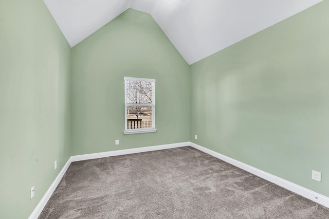 carpeted empty room featuring vaulted ceiling