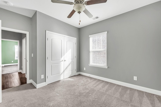 unfurnished bedroom with carpet floors, ceiling fan, and a closet