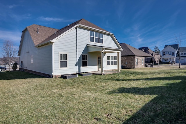 back of property featuring a patio area and a lawn